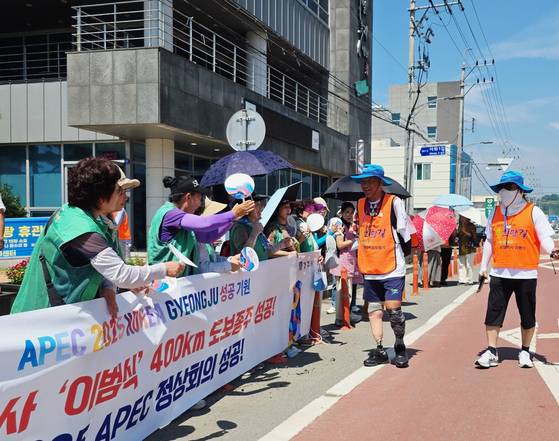 아시아태평양경제협력체(APEC) 정상회의 성공개최를 기원하며 국토 걷기에 나선 '왼발박사' 이범식씨가 24일 APEC 개최도시인 경북 경주에 도착해 시민 환영을 받으며 걷고 있다. 사진 경주시