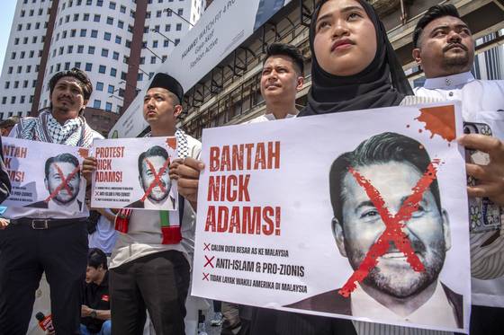 Activists hold placards depicting Trump's nominee for U.S. ambassador to Malaysia, Nick Adams, during a protest outside the US Embassy in Kuala Lumpur, Malaysia on July 18. [EPA/YONHAP]