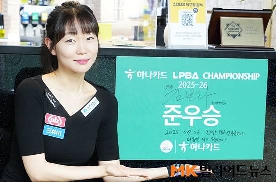 김보라는 대회 일주일 전 연습구장을 찾았을 때 테이블 천이 하나카드 색깔인 초록색으로 바뀐걸 보고 자신감을 얻었다고 한다. 준우승 사인이 들어있는 액자를 들어보이는 김보라.