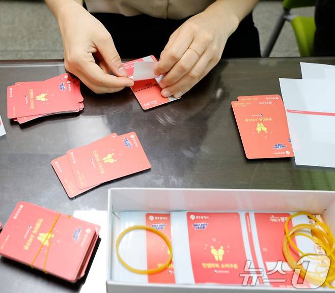 광주시가 민생 회복 소비쿠폰 선불카드의 액수별 '카드 색상'을 다르게 배부해 논란이 인 가운데 24일 광주 한 행정복지센터에서 공직자들이 선불카드에 스티커 부착 작업을 하고있다. /사진=뉴스1