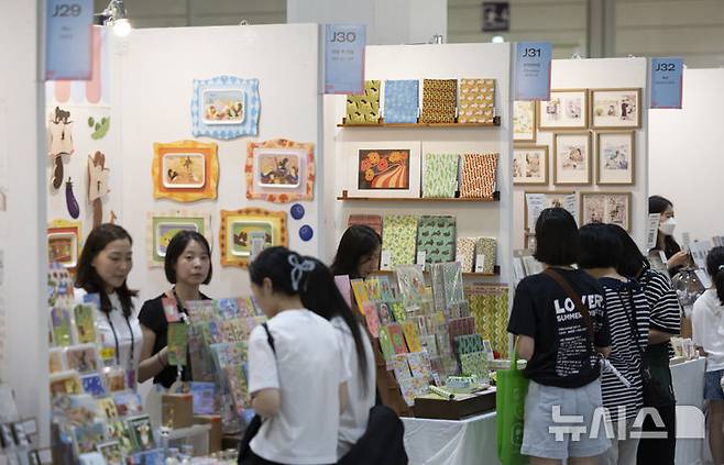 [서울=뉴시스] 김근수 기자 = 서울일러스트레이션페어V.19 2025 개막 첫 날인 24일 서울 강남구 코엑스에서 관람객들이 일러스트 그림 엽서를 구경하고 있다. 2024.07.24. ks@newsis.com
