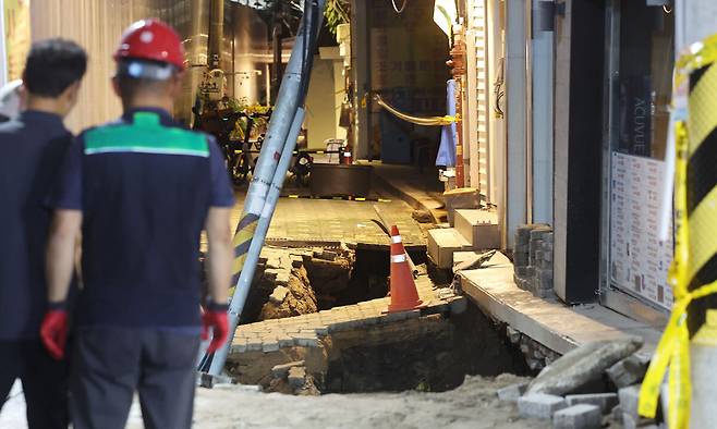 23일 서울 동대문구 이문동의 한 공사장에서 지반 침하가 발생, 관계자들이 현장을 살펴보고 있다. 연합뉴스