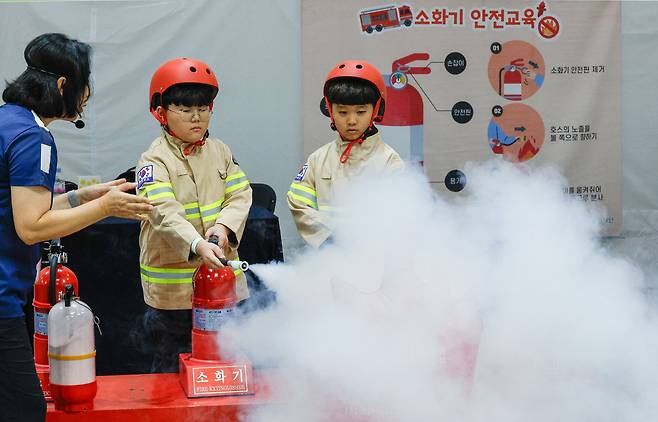24일 경기 고양시 일산서구 킨텍스에서 2025 어린이 통합 안전 박람회가 열린 가운데 어린이들이 소화기 안전체험을 하고 있다.