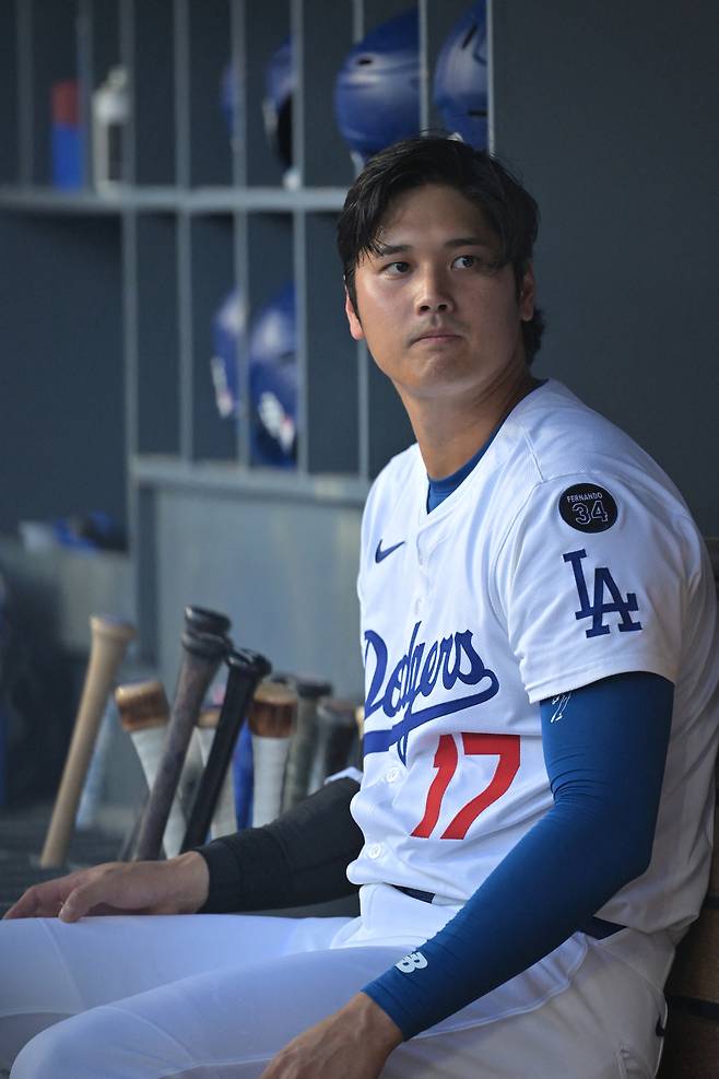 LA 다저스 오타니 쇼헤이가 24일 미네소타전에서 덕아웃에 앉아서 뭔가를 바라보고 있다. Imagn Images연합뉴스