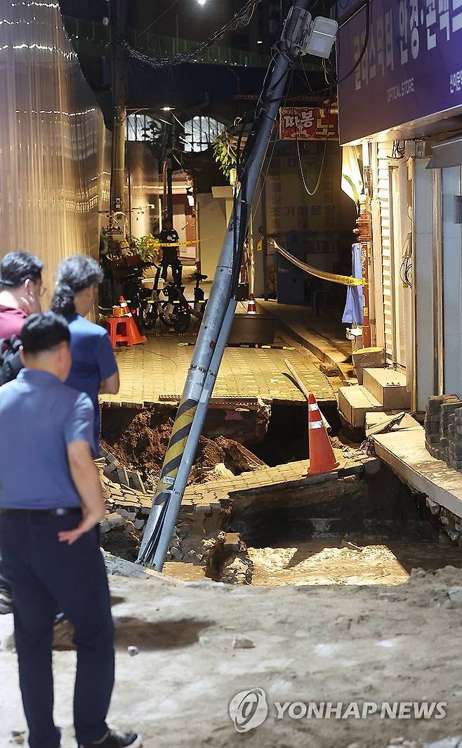 서울 동대문구 공사장서 2ｍ 지반 침하 (서울=연합뉴스) 김주형 기자 = 23일 서울 동대문구 이문동의 한 공사장에서 지반 침하가 발생, 관계자들이 현장을 살펴보고 있다.
    동대문구청에 따르면 이문2동 복합청사 부설주차장 공사장에서 깊이 2m, 길이 5m 규모로 땅이 꺼졌다. 이로 인해 인근 건물이 기울어져 내부에 있던 공사장 인부 1명이 갇혔다가 구조됐다. 다른 인명피해는 현재까지 없는 것으로 파악됐다고 밝혔다. 2025.7.23 kjhpress@yna.co.kr