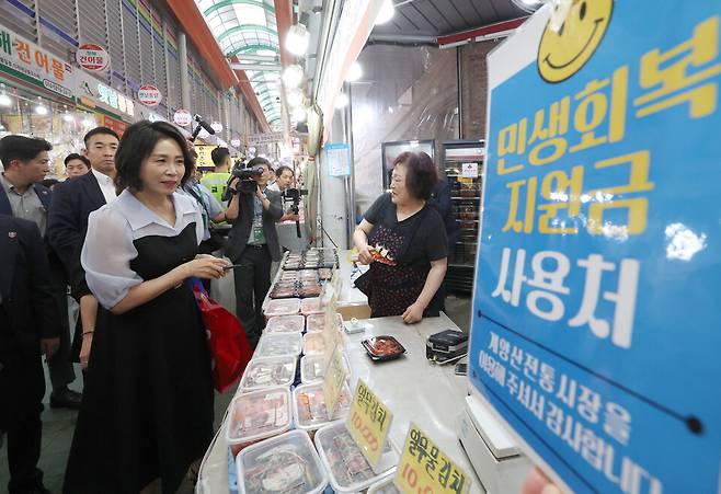 ▲&nbsp;김혜경&nbsp;여사가 25일 인천 계양산전통시장을 방문해 민생회복 소비쿠폰을 이용해 꽈배기를 구매하고 있다. /연합뉴스