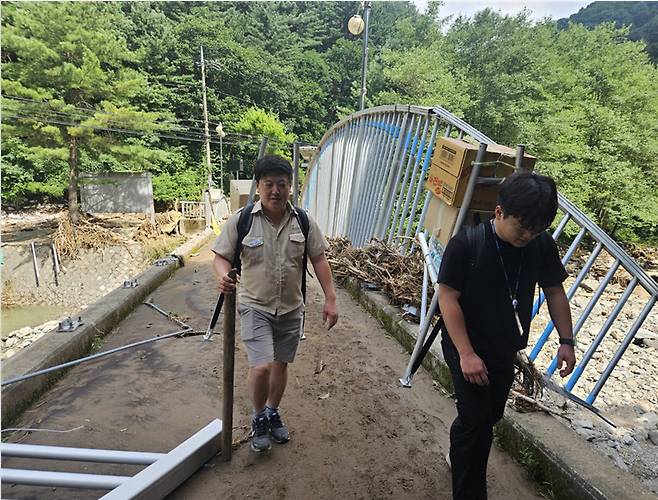 경기도 연인산도립공원 소속 공무원들이 가평군 호우 피해 당시 지게를 지고 구호물품을 나르는 모습. 사진=경기도청