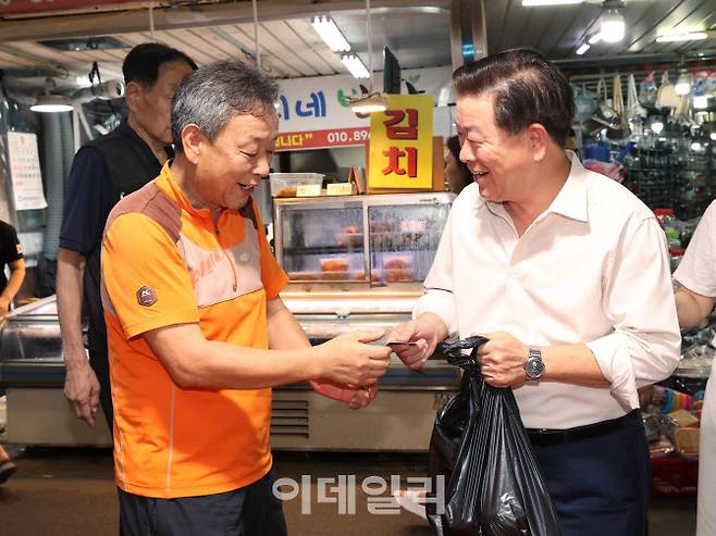 박승원 광명시장이 지역화폐인 광명사랑화폐를 이용해 전통시장에서 장을 보고 있다.(사진=광명시)