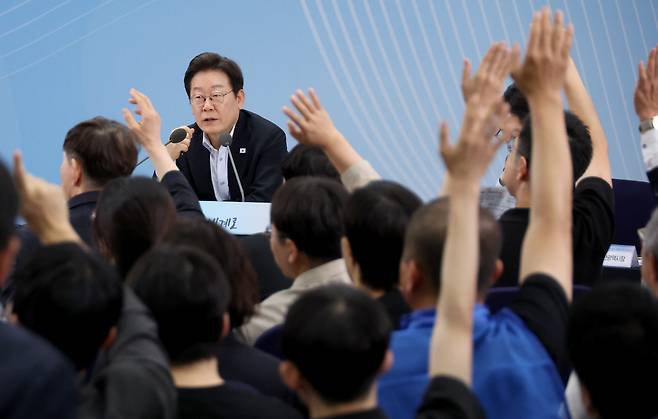 25일 부산 부경대에서 이재명 대통령이 참석한 가운데 열린 타운홀미팅 '부산의 마음을 듣다' 간담회에서 시민들이 손을 들어 발언권을 요청하고 있다. /연합뉴스