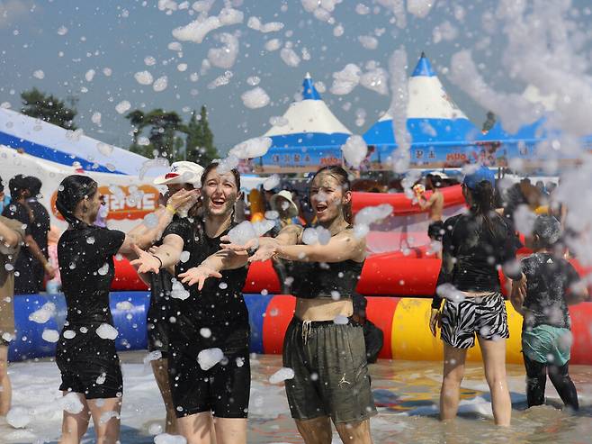 머드축제 첫날인 25일 오후 충남 보령시 대천해수욕장을 찾아온 관광객들이 폭염경보의 불더위 속에서도 축제를 즐기고 있다. 연합뉴스.