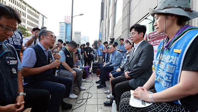 25일 서울 중구 세종호텔 앞 고공농성장을 찾은 김영훈 고용노동부장관(중앙 오른쪽)이 노조 관계자들과 마주 앉아 얘기를 나누고 있다. 고용노동부 제공