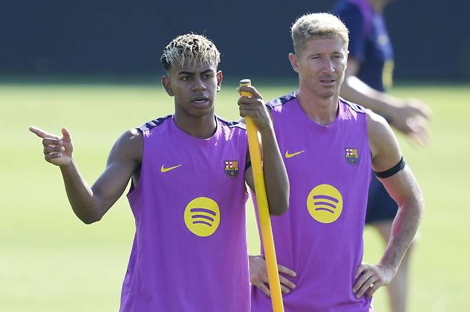 epa12242502 FC Barcelona's soccer player Lamine Yamal (L) and Robert Lewandowski (R) during a team training session at Joan Gamper Sports City in Barcelona, Spain, 17 July 2025. EPA/Enric Fontcuberta