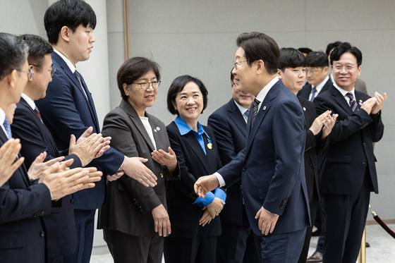 이재명 대통령이 23일 서울 용산 대통령실 청사에서 열린 임명장 및 위촉장 수여식에서 정은경 보건복지부 장관과 인사를 마치고 옆에 선 정 장관의 아들과 악수하고 있다. 김현동 기자