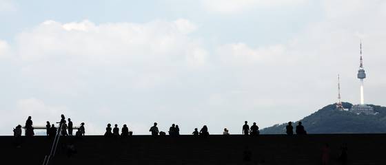 전국에 폭염경보가 내려진 24일 서울 용산구 국립중앙박물관 계단에서 시민들이 파란 하늘을 보고 있다. [뉴스1]
