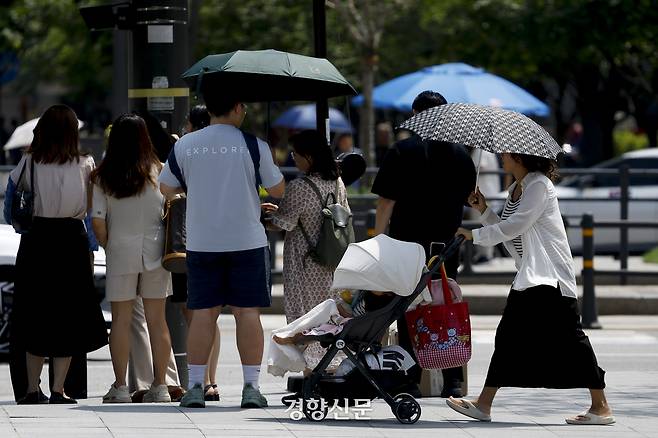 서울의 한낮 기온이 34도로 폭염이 이어지고 있는 24일 서울 도심에서 시민들이 양산을 쓴 채 햇살을 피하고 있다. 문재원 기자