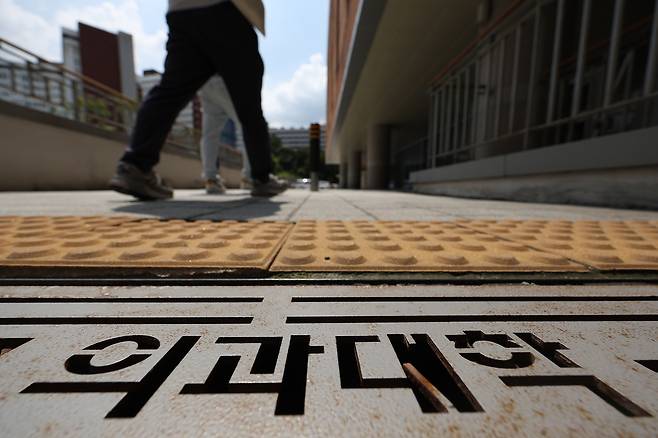 지난 23일 서울 시내 의과대학 건물 앞을 한 학생이 지나가고 있다.  연합뉴스