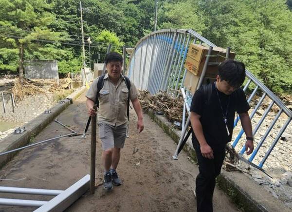 지게로 구호품 나르는 신희섭(왼쪽)·박수완(오른쪽) 주무관. 경기도 제공