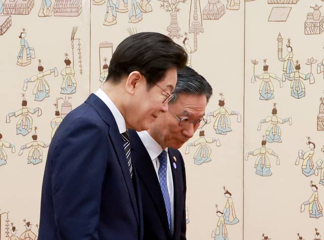 이재명 대통령이 23일 서울 용산 대통령실 청사에서 열린 임명장 및 위촉장 수여식에서 정성호 법무부 장관과 기념촬영 뒤 자리를 옮기고 있다.  연합뉴스