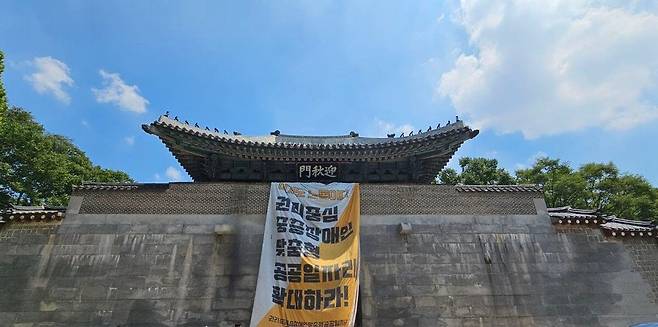 서울 종로구 경복궁 영추문에 25일 전국장애인차별철폐연대(전장연)이 설치한 장애인 권리 보장을 요구하는 대형 현수막이 걸려있다. 전국장애인차별철폐연대 제공