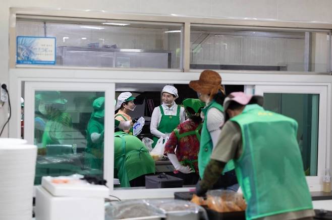 김혜경 여사, 수해복구 현장서 봉사활동 - 이재명 대통령 부인 김혜경(가운데) 여사가 24일 집중호우로 큰 피해를 본 경기 가평군 백둔리를 찾아 마을회관에서 자원봉사자들과 함께 대민 지원 활동에 나선 군장병 300여명에게 줄 점심 식사 준비를 하고 있다. 비공개로 진행된 이날 일정에서 김 여사는 침수 피해가 큰 가옥을 찾아 흙탕물로 뒤덮인 그릇과 가재도구를 씻어내는 작업을 했고 이후 점심 배식 봉사 후 자원봉사자들과 식사한 뒤 설거지를 하며 이날 활동을 마무리했다. 대통령실 제공