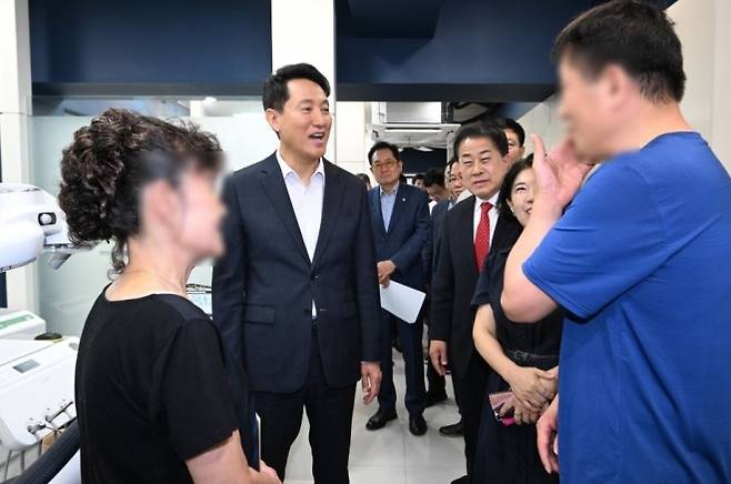 서울역쪽방상담소 ‘우리동네 구강관리플러스센터’에서 열린 ‘개소 1주년 성과공유회’에 참석한 김용호 의원(오른쪽)이 오세훈 서울시장과 함께 센터를 둘러보며 센터 이용 주민과 대화를 나누고 있다.