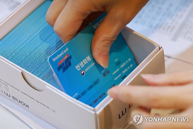 1차 신청 시작한 민생회복 소비쿠폰 민생회복 소비쿠폰 신청이 시작된 7월 21일 서울 동작구 대방동주민센터에서 직원이 소비쿠폰 신청을 받고 있다.[연합뉴스 자료사진]