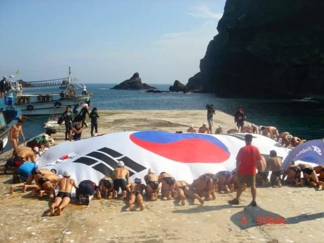 2004년 ‘울릉도-독도 수영종단’을 성공적으로 마친 참가자들이 태극기 퍼포먼스를 펼치고 있다. 사진 | 독도사랑회