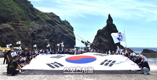 22일 행사 참가자들이 독도에 입도 후 태극기 퍼포먼스를 펼치고 있다. 사진 | 이상배 전문기자