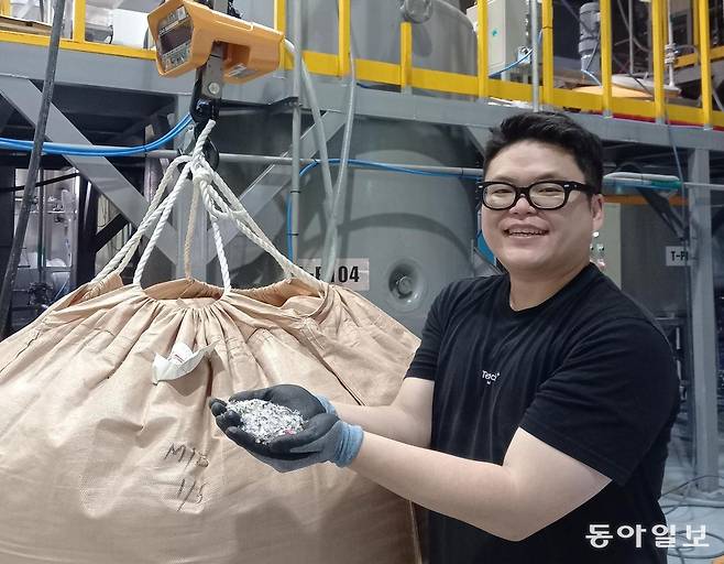 권기백 테라클 대표이사가 지난달 23일 인천 사업장에 있는 해중합시설 공장에서 원료로 쓰이는 색상 있는 페트병 조각들을 들어보이고 있다. 투명하지 않은 페트병도 테라클의 기술 덕분에 재활용이 쉬워졌다. 인천=허진석 기자 jameshur@donga.com