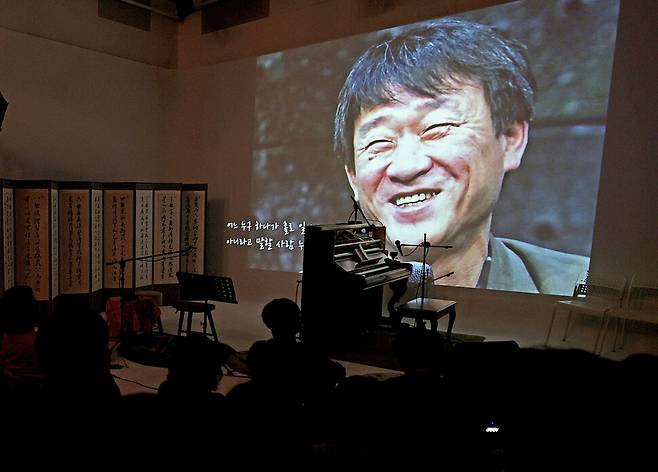 환하게 웃는 김민기 전 학전 대표의 생전 모습이, 전선영 감독이 고인을 기리며 제작한 영상에 담겨 나오고 있다.