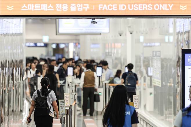 한산한 T1 스마트패스 전용 출입구 너머로 붐비는 일반여객 출입구가 보인다.