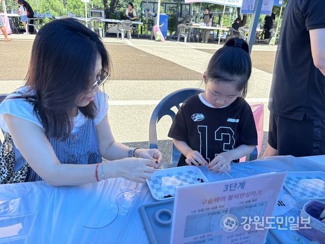 ▲ ‘나라꽃 무궁화 홍천 축제’가 26일 무궁화수목원에서 열린 가운데 농촌유학 중인 송희(사진 왼쪽) 씨가 딸과 함께 무궁화 팔찌 만들기 체험을 하고 있다. 유승현 기자