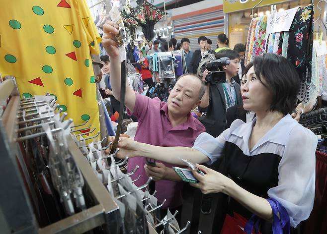 김혜경 여사가 25일 민생회복 소비쿠폰 이용을 위해 인천 계양산전통시장을 방문해 의류 매장에서 남성용 벨트를 살피고 있다. 2025.7.25 [대통령실통신사진기자단]