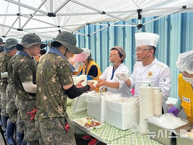 [서울=뉴시스] 넷플릭스 흑백요리사에 출연한 안유성 명장이 군 장병과 주민들에게 음식을 전달하는 중이다.(사진=나주시 제공). 2025.07.25.