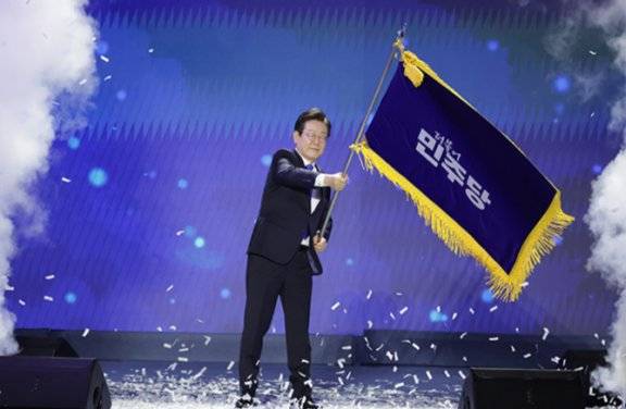 이재명 대통령이 지난해 8월 18일 서울 송파구 올림픽체조경기장에서 열린 더불어민주당 전당대회에서 당 대표 연임에 성공한 뒤 당기를 흔들고 있다. 동아DB