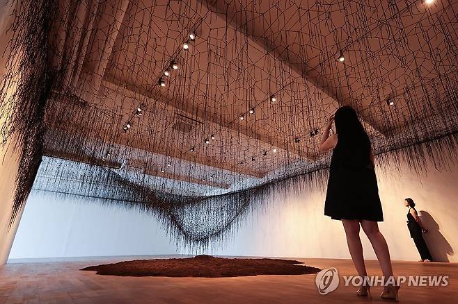 시오타 지하루의 작품 세계 (서울=연합뉴스) 류효림 기자 = 25일 서울 종로구 평창동 가나아트센터에서 열린 시오타 지하루 개인전 '리턴 투 어스'(RETURN TO EARTH) 기자간담회에서 참석자들이 전시 작품을 살펴보고 있다. 2025.7.25 ryousanta@yna.co.kr
