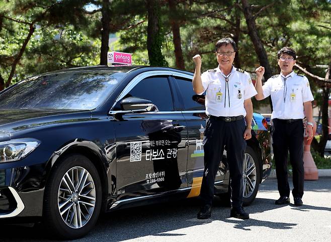 권용철(왼쪽)·이창신 관광택시 기사가 지난 24일 포항시청 앞에서 “타보소 관광 택시 화이팅”을 외치고 있다. /이용선기자 photokid@kbmaeil.com