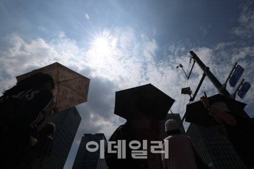 서울에 폭염 경보가 내려진 24일 서울 종로구 광화문광장 일대에서 시민들이 양산을 쓴 채 이동하고 있다. (사진=이영훈 기자)