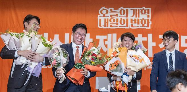 개혁신당 당 대표 선거에 단독 출마한 이준석 의원이 27일 국회의원회관 대회의실에서 열린 개혁신당 제2차 전당대회에서 당 대표로 확정된 뒤 최고위원 선출자들과 꽃을 받고 있다.     (왼쪽부터) 김정철, 김성열 최고위원, 이 대표, 주이삭 최고위원/연합뉴스