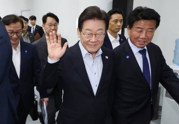 이재명 대통령이 25일 부산 부경대에서 열린 타운홀미팅 '부산의 마음을 듣다' 간담회를 마친 뒤 행사장을 떠나며 시민들을 향해 인사하고 있다. 연합뉴스