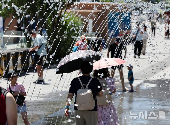 [서울=뉴시스] 배훈식 기자 = 전국 대부분 지역에 폭염특보가 내려진 27일 오전 서울 종로구 광화문광장에서 시민들이 분수터널을 걸으며 더위를 식히고 있다. 2025.07.27. dahora83@newsis.com