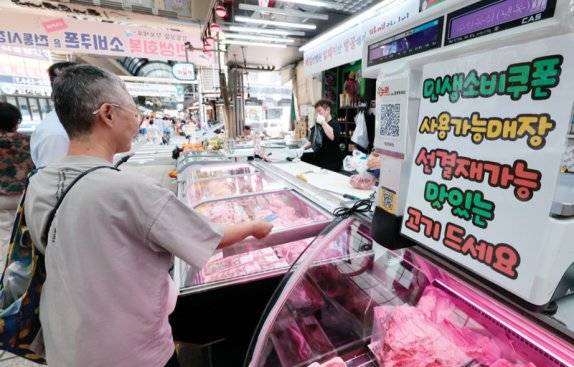 7월 22일 서울 강동구 암사종합시장 정육점에 민생회복 소비쿠폰&nbsp;사용 가능 매장 안내문이 붙어 있다. 뉴스1