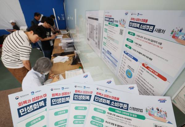 '민생회복 소비쿠폰'의 1차 신청 첫날인 지난 21일 오전 경기 수원시 팔달구 인계동행정복지센터에서 시민들이 신청서를 작성하고 있다. 뉴스1