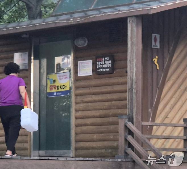 강원 강릉에 가뭄과 폭염이 심각했던 지난 25일 강릉시 성산면 어흘리 대관령옛길 반정 전망대 공중화장실에 한 캠핑족에 일명 '말통'을 들고 화장실로 향하고 있다. 화장실 입구에 붙여진 '물을 절약합시다'라는 문구가 눈에 띈다. 이날 강릉지역 주 취수원인 오봉저수지의 저수율은 30%대를 간신히 유지하고 있었다. 2025.7.28/뉴스1 윤왕근 기자