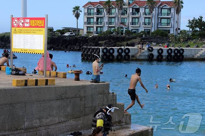 27일 오후 제주시 한림읍 월령포구에서 사람들이 다이빙을 하고 있다. 하루 전 이곳에서는 20대 남성이 물놀이 중 익수사고로 사망했다.2025.7.27/뉴스1 ⓒ News1 홍수영 기자