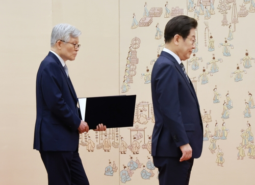 최동석 인사혁신처장이 지난 23일 서울 용산 대통령실 청사에서 열린 신임 국무위원, 지방시대위원장 임명장 및 위촉장 수여식에서 이재명 대통령의 임명장 수여를 돕고 있다. [연합뉴스]