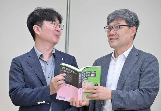 '서울대 교수들이 말하는 탄소중립을 위한 기술혁명'의 공동 저자인 서울대의 구윤모(왼쪽) 기술경영학과 교수와 윤제용 화학생물공학과 교수가 24일 서울 관악구 서울대 공학관에서 한국일보와 인터뷰 중 책을 소개하고 있다. 강예진 기자
