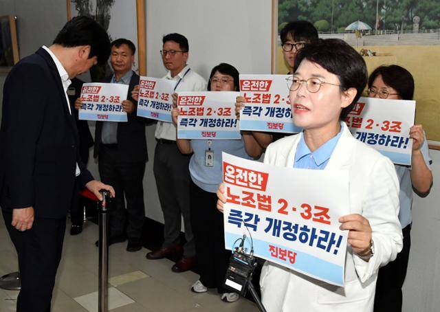전종덕(오른쪽) 진보당 의원이 28일 서울 여의도 국회 환경노동위원회 소회의실 앞에서 고용노동법안심사소위원회에 참석하는 의원들을 향해 노조법 개정을 촉구하는 손팻말을 들고 있다. 환노위는 이날 소위를 열고 노조법 2·3조 개정안(노란봉투법)을 심사했다. 고영권 기자