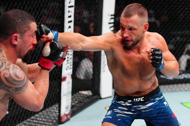 레이니어 더 리더(오른쪽)가 휘태커에게 주먹을 뻗고 있다. 사진=UFC
