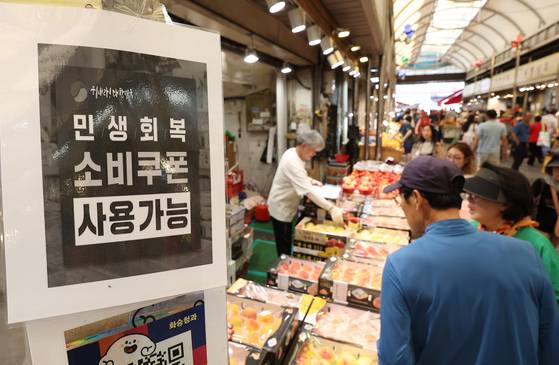 민생회복 소비쿠폰 지급 후 첫 주말인 지난 27일 서울 동대문구 청량리종합시장 한 가게에 쿠폰 사용이 가능하다는 안내문이 붙어 있다. 연합뉴스